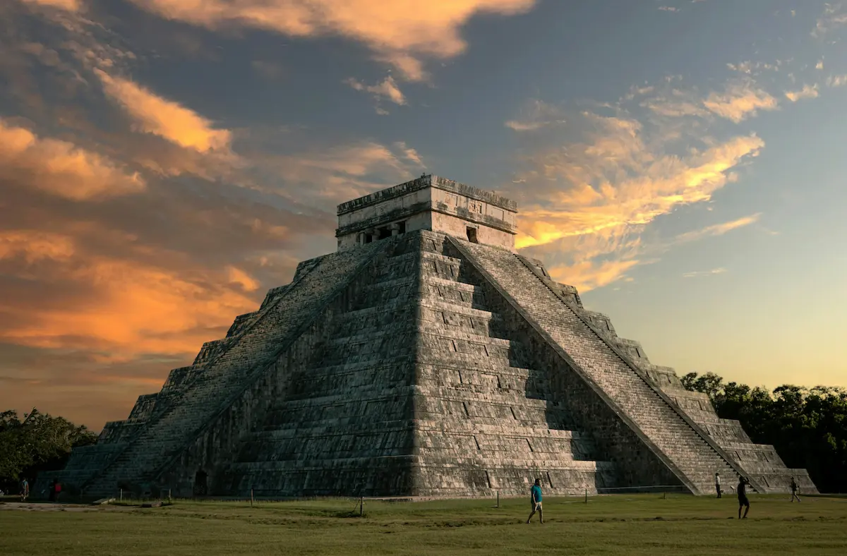 Chichen Itza pyramid at sunset with dramatic sky and travelers — best eSIM for Mexico travel 2026