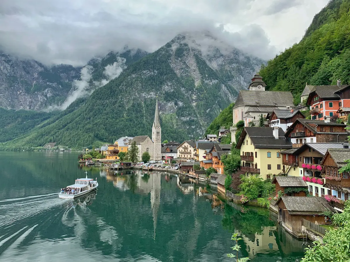 Hallstatt Austria lake village with Alps mountains and church reflection — best eSIM for Austria travel 2026