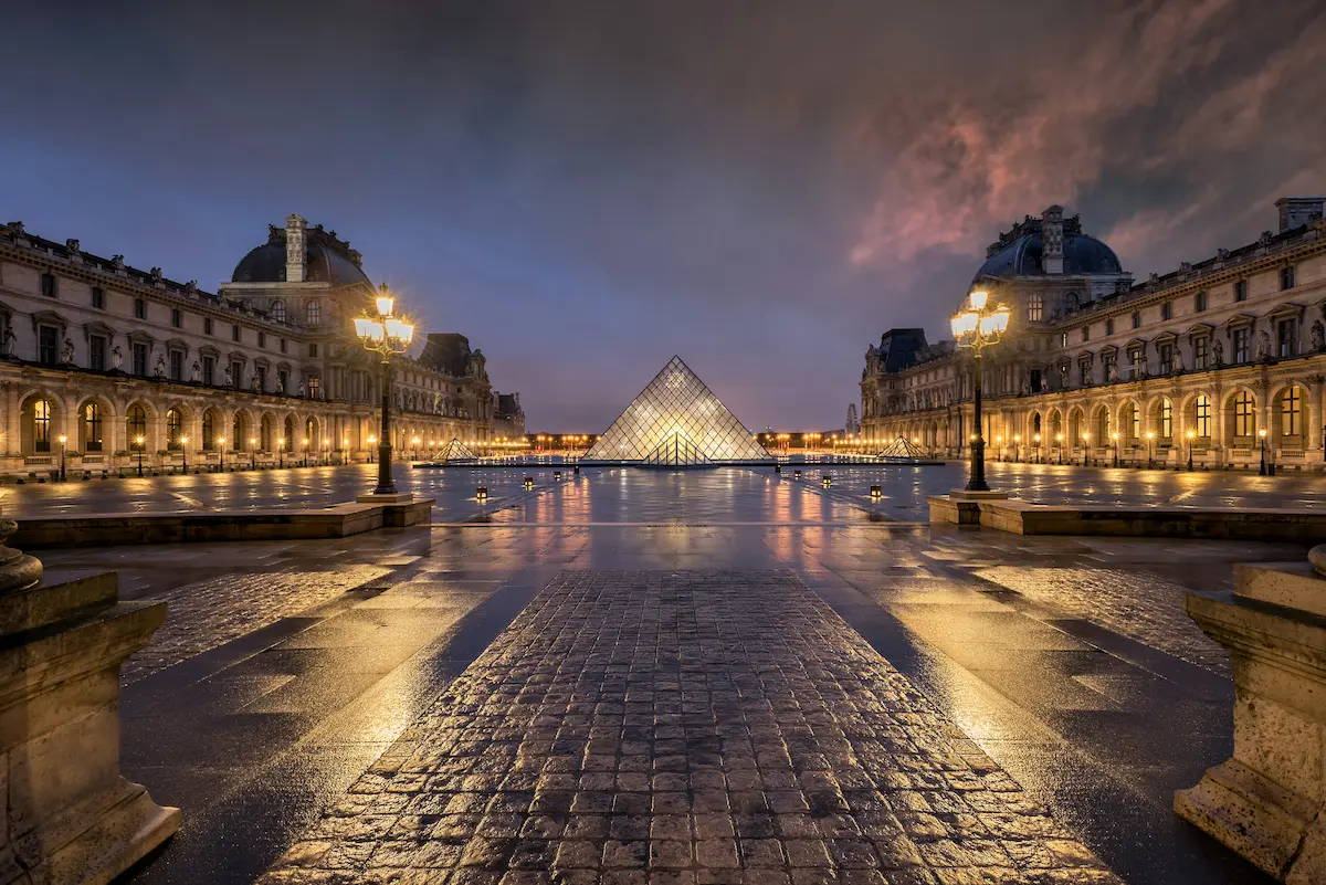 Pirámide del Louvre en París de noche con reflejo y luz urbana louvre paris noche reflejo mejor esim para francia 2026 cobertura real