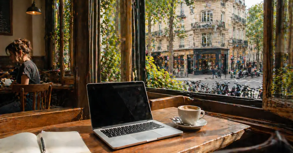 working remotely in paris cafe with laptop and coffee near window showing daily mobile data usage